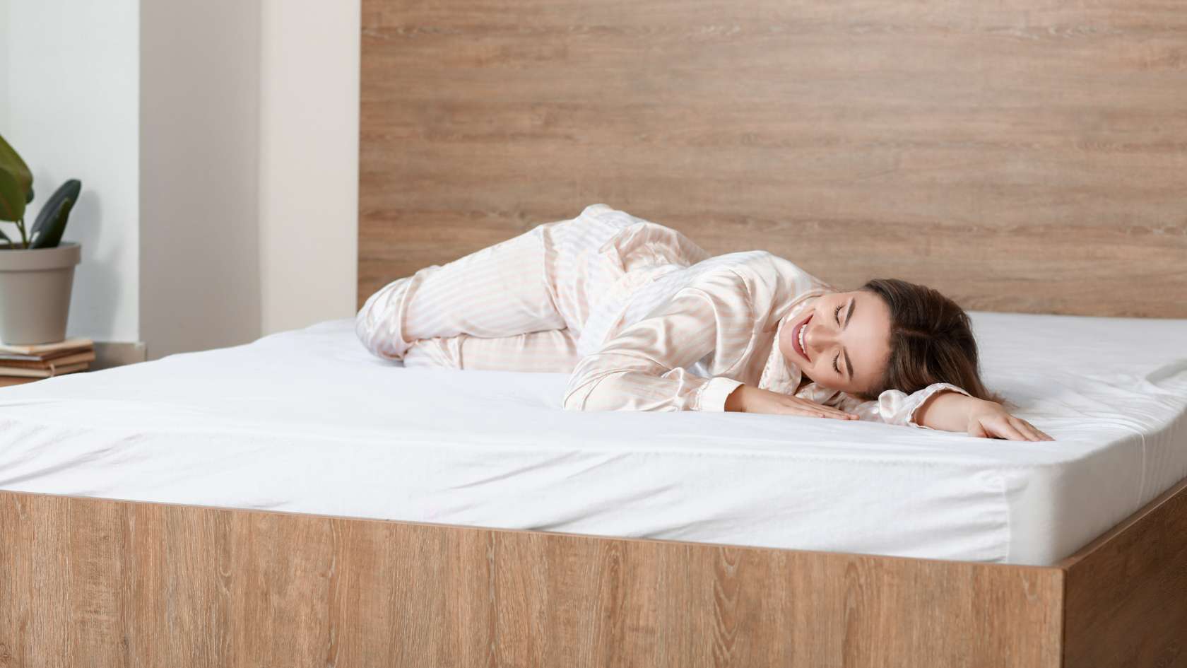 Woman lying down and smiling on clean mattress