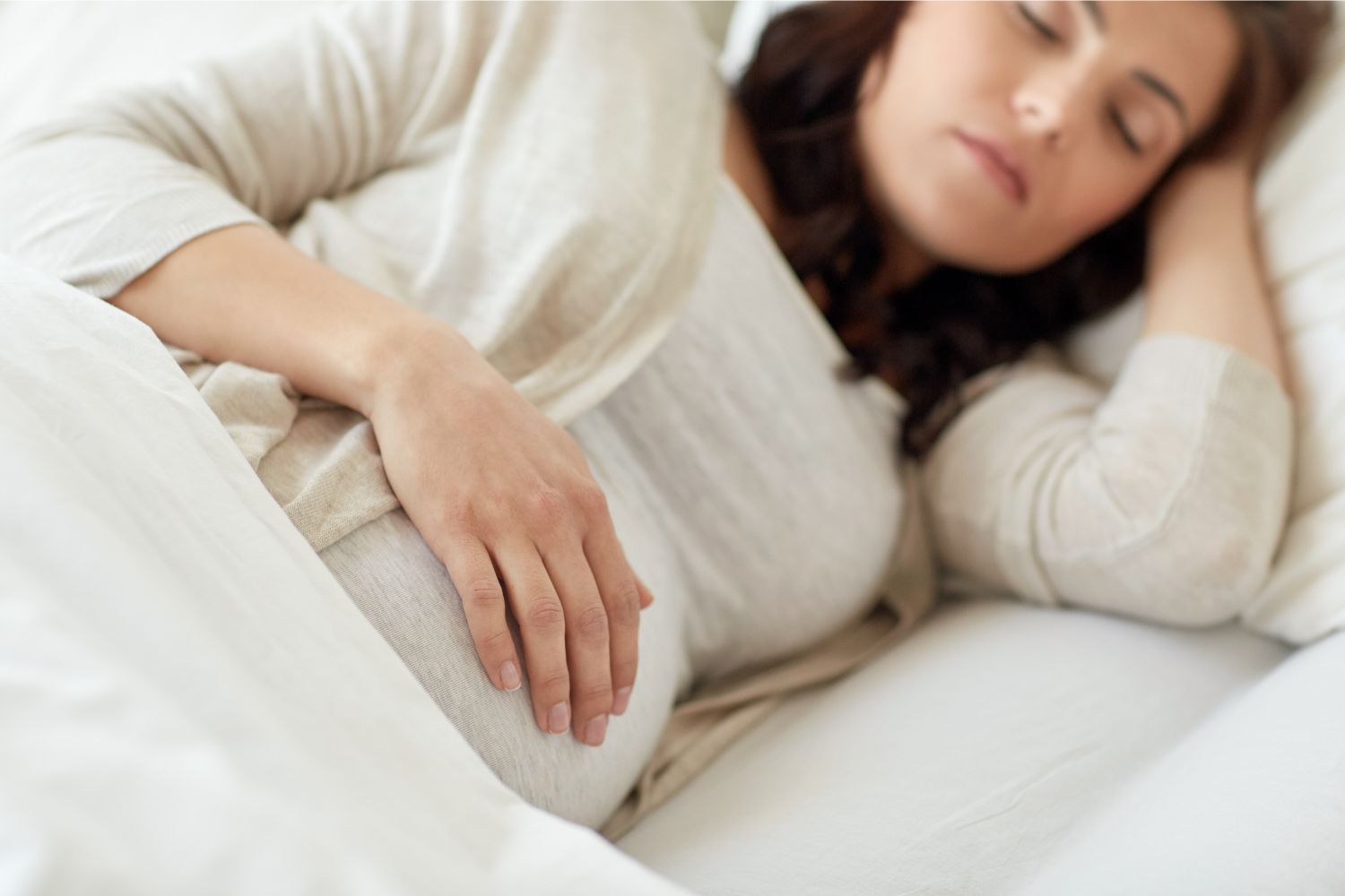 Pregnant woman sleeping on side in bed