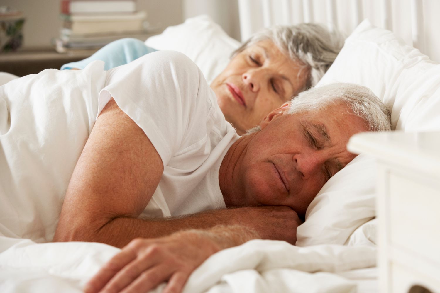 Seniors asleep in bed