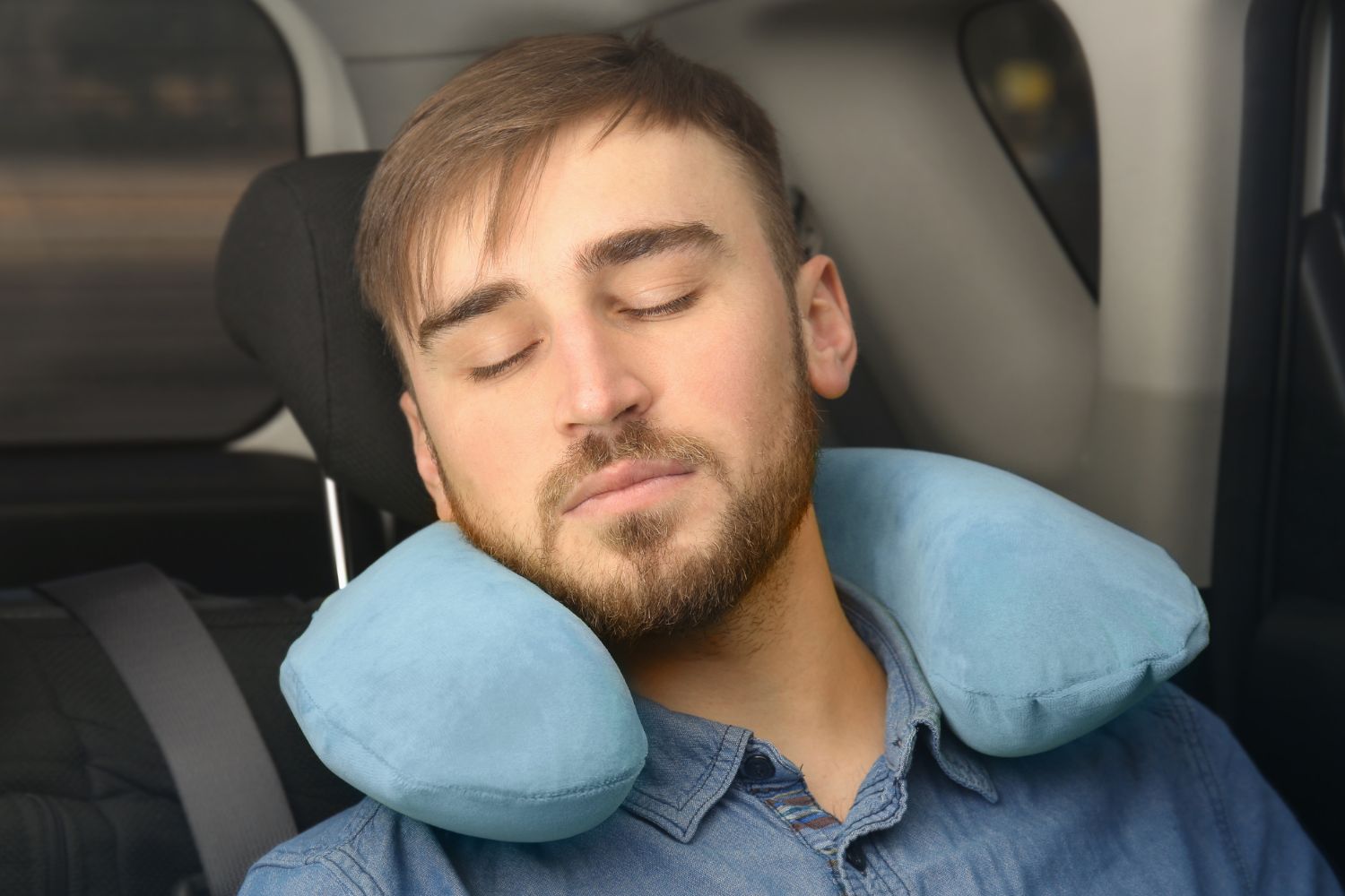 Man sleeping in a car while travelling